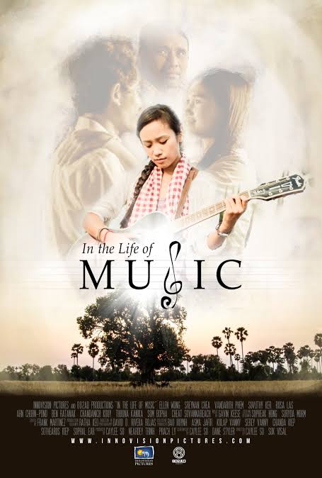 The main actor stands center holding a guitar